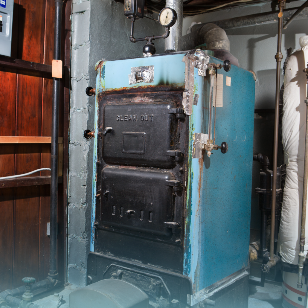 Old gas furnace showing rust and wear, highlighting potential carbon monoxide leak risks in residential heating systems