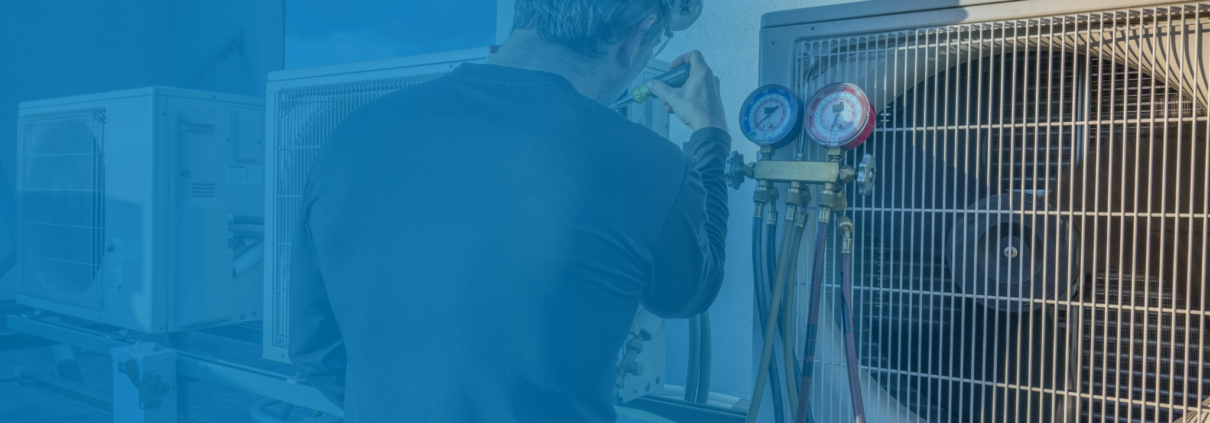 HVAC technician repairing an outdoor air conditioning unit.